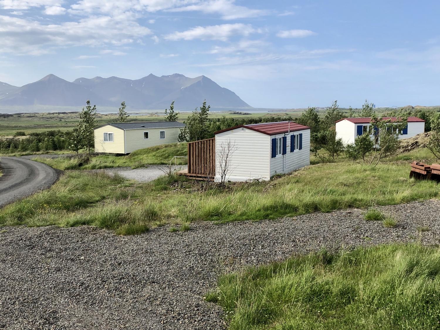 Summer overview of Lækjarkot cottages and green grounds beneath the Borgarfjörður mountains